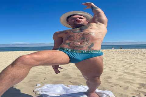 Conor McGregor does stretches in his budgie smugglers as UFC icon hits beach with pregnant fiancee..